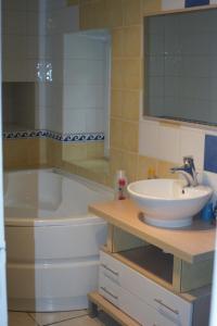 La salle de bains est pourvue d'une baignoire, d'un lavabo et d'un miroir. dans l'établissement Le p'tit hameau de Sey, à Quettehou