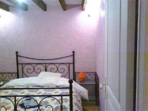um quarto com uma cama e uma parede branca em Le p'tit hameau de Sey em Quettehou