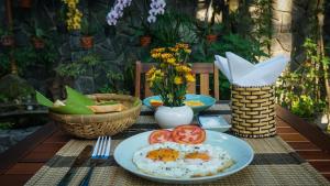 a table with plates of eggs and tomatoes on it at Hanh Nhung Villa in Hoi An