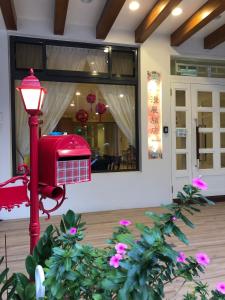 a red lamp in front of a building with flowers at 南庄漫晨旅店Nanzhuang Manchen B&B in Nanzhuang