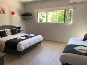 a bedroom with two beds and a window at L’île aux Bateaux in Buzet-sur-Baïse