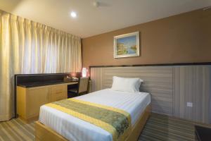 Habitación de hotel con cama y escritorio en Hallmark Leisure Hotel en Melaka