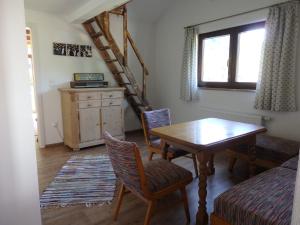 a living room with a table and chairs and a staircase at Amsel Haus in Bayrischzell