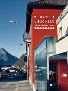 un edificio rosso con un cartello per un bar di riferimento epidemico dell'hotel di Hotel Cereda a Sementina
