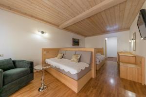 1 dormitorio con cama, sofá y TV en Kunstelj Pension en Radovljica