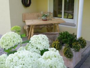 Ein Strauß weißer Blumen liegt neben einem Tisch. in der Unterkunft Allgäuvilla in Scheidegg