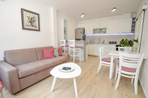 a living room with a couch and a table and a kitchen at Seafront apartment Vujovic in Prčanj