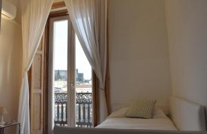 a bedroom with a bed and a window with a balcony at La Casa nel Borgo Antico in Melfi