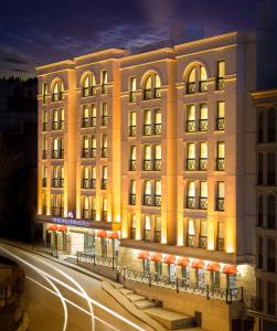 un gran edificio con luces frente a una calle en Metropolitan Hotels Taksim, en Estambul