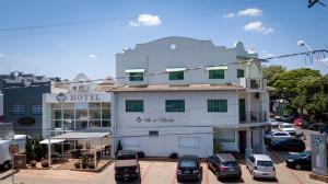 a building with cars parked in a parking lot at Hotel Villa de Holanda in Holambra