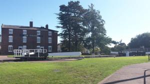 un gran edificio de ladrillo con un parque infantil delante de él en JJ's "Gin Palace" luxury riverside town house en Stourport