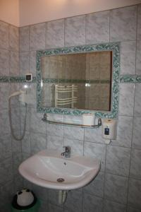 a bathroom with a sink and a mirror at Ośrodek Wypoczynkowy Rapsodia in Krynica Zdrój +29 photos