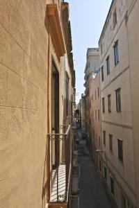 un callejón entre 2 edificios con balcón en La Lampara, en Trapani