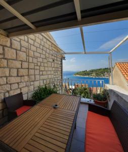 einen Holztisch auf einer Terrasse mit Meerblick in der Unterkunft Apartments Rosso in Hvar
