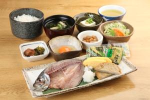 a plate of food with a fish on a table at Hotel Bellreaf Otsuki in Otsuki