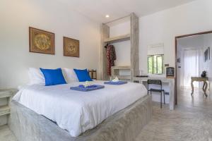ein Schlafzimmer mit einem großen Bett mit zwei blauen Gerichten darauf in der Unterkunft Aloe Villa in Ko Tao