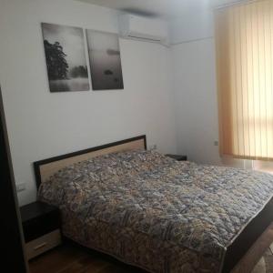 a bedroom with a bed and a picture on the wall at Fashion Apartments in Sandanski