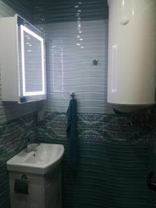 a bathroom with a toilet and a sink and a window at Fashion Apartments in Sandanski