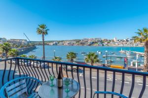 d'une table et de chaises sur un balcon avec vue sur l'eau. dans l'établissement Harbour Lights seafront 2 bedroom apartments with panoramic sea views - by Getawaysmalta, à San Pawl il-Baħar