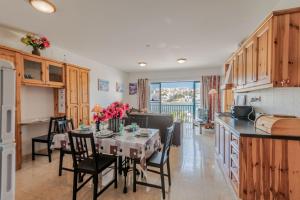 a kitchen and dining room with a table and chairs at Harbour Lights seafront 2 bedroom apartments with panoramic sea views - by Getawaysmalta in St. Paul's Bay