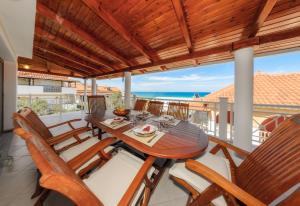 ein Esszimmer mit einem Tisch und Stühlen auf dem Balkon in der Unterkunft Villa Eleni in Alikanas