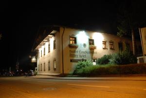 un edificio sul lato di una strada di notte di Hotel Alter Wirt a Weyarn