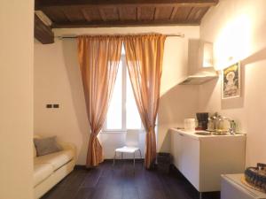 salon z kanapą i oknem w obiekcie House Monti 1875 w Rzymie