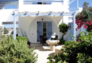 een tuin voor een huis met een fontein bij Niriides Boutique Apartments in Koufonisia