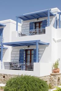 biały budynek z niebieskimi balkonami i oknami w obiekcie Niriides Boutique Apartments w Koufonisii