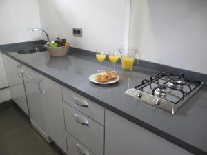 a kitchen with two glasses of orange juice and a plate of food at Life Apartments El Rompido in El Rompido