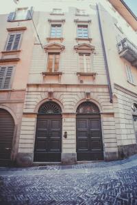 a building with two black doors on a street at Divino Suite 2.0 in Bergamo