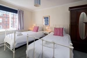 ein Schlafzimmer mit zwei Betten und einem Spiegel in der Unterkunft Pear Tree Cottage in Aldeburgh