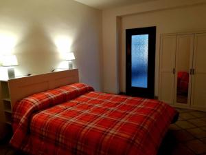 a bedroom with a red bed and a window at Case Gemelle - CIR 0271 in Aosta