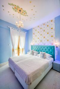 um quarto azul com uma cama e um lustre em Rozmari and Spa em Agia Galini