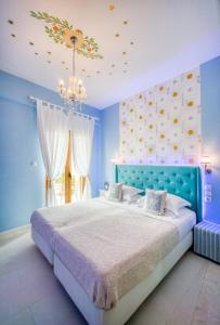 a blue bedroom with a bed and a chandelier at Rozmari and Spa in Agia Galini