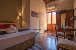 Un dormitorio con una cama, un escritorio y una silla. en Cappuccine GuestHouse, en Cagliari