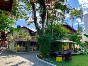 a house with a table and an umbrella at Beira Mar in Ubatuba +21 photos