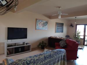 a living room with a couch and a tv at Hostel Casa Grande in Porto Alegre