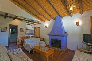 sala de estar con chimenea y mesa en Villa La Clavelina Rocabella, en El Chorro