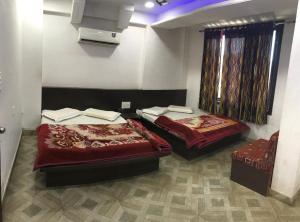
a hotel room with two beds and two night stands at Hotel Hari darshan in Nāthdwāra
