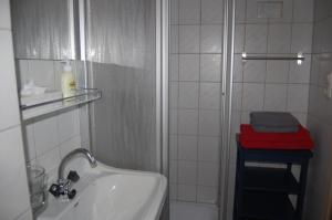 a white bathroom with a sink and a shower at Gasthof Martinihof in Latschach ober dem Faakersee