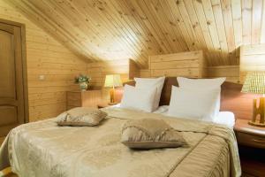 1 dormitorio con 1 cama con 2 almohadas en Svetliy Terem Hotel en Suzdal