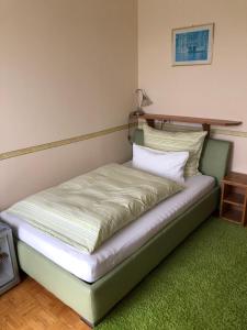 łóżko stojące w pokoju z zielonym dywanem w obiekcie Haus Camelia w mieście Bad Tatzmannsdorf