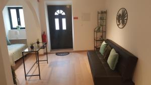 uma sala de estar com um sofá e uma porta preta em Casa S. Tiago em Setúbal