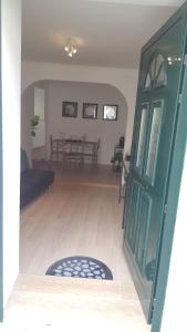 uma sala de estar com uma porta verde e uma mesa em Casa S. Tiago em Setúbal