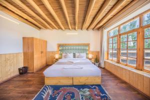 レーにあるThe Silk Route Ladakhの窓のある部屋にある大きなベッドのある寝室