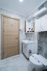 a bathroom with a toilet and a sink and a mirror at ATAM HOTEL in Istanbul