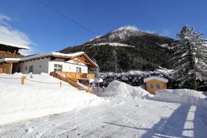 una casa ricoperta di neve con una montagna sullo sfondo di Ferienhaus Weixelbraun a Mallnitz