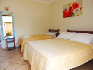 a bedroom with a bed, desk, mirror and window at Pousada Mosaico Brasil - Maresias in Maresias