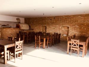 restauracja z drewnianymi stołami i krzesłami oraz ceglaną ścianą w obiekcie Penzion Vinařství Fabikovič w mieście Velké Bílovice +34 zdjęcia